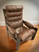 A Scandinavian brown stitched leather and stained wood lounge armchair.