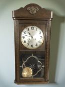 An oak Junghans wall clock, height 77 cm.
