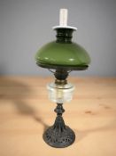 A patinated metal oil lamp with green shade, height 61 cm.