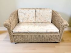 A wicker two seated conservatory settee, width 160 cm, matching armchair and coffee table.