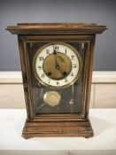 An early 20th century walnut eight day mantel clock, striking on a gong, with pendulum,