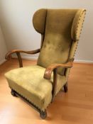 An early 20th century oak framed wingback armchair.