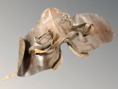 A vintage leather saddle, with stirrups.