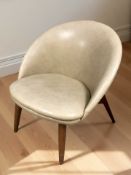 A Scandinavian cream vinyl lounge chair.