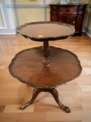 A mahogany two tier scalloped edge occasional table, height 75 cm.