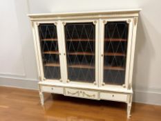 A continental painted and gilt triple door display cabinet, 155 cm x 48 cm x 157 cm.