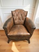 An early 20th century studded brown leather armchair, width 76 cm.