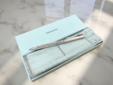 A Tiffany & Co silver ball-point pen, the clip in the form of a golf ball on a tee, boxed.