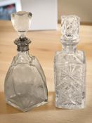A cut crystal decanter and a further etched decanter with silver plated collar, height 30 cm.
