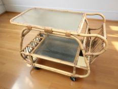A wicker and glass two tier serving trolley, length 85 cm.