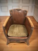 An early 20th century studded brown leather armchair.