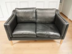 A contemporary Danish two seater black leather settee, width 142 cm.