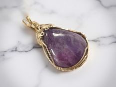A sugilite pendant, in yellow gold ropework mount, length 36mm. CONDITION REPORT: 5.