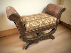 An early 20th century faux leather X-framed stool, width 62 cm.