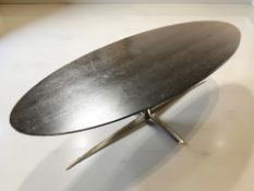 A Scandinavian stained ash oval coffee table on chrome support, length 140 cm.