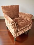 A 20th century armchair in peach floral fabric.