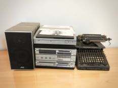 A JVC hi-fi system, a pair of speakers and a vintage Smith Premier typewriter.