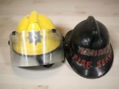 A Royal Air Force Fire Fighting and Rescue Service helmet and a further reproduction fire helmet