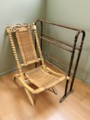 A folding chair with wicker seat and antique towel rail