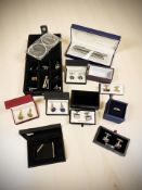 A collection of designer cuff links, Swarovski rings, lighter,