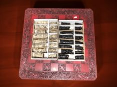 A resin chess board and set of oriental style chess pieces,
