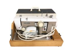 A New Home electric sewing machine with lead and pedal.