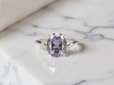 A 9ct white gold tanzanite ring with diamond-set shoulders, size M.