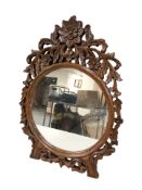 An Eastern carved hardwood mirror,