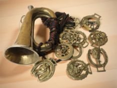 A brass and nickel bugle, and a group of horse brasses.