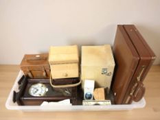 A reproduction wall clock, several boxes, stitched leather suitcase,