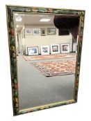 A contemporary bevelled mirror in a floral frame, 82 cm x 111 cm.