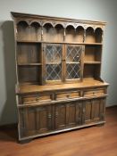 A reproduction carved oak and leaded glass dresser,