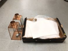 A quantity of white table cloths and copper effect tea light lanterns