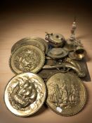 A group of embossed brass plaques, school bell, pistols, etc.