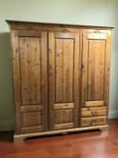 A modern pine triple door wardrobe,