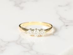 A 9ct gold three stone diamond ring, the stated total diamond weight 0.