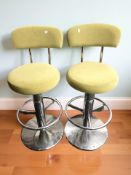 A pair of chrome swivel bar chairs