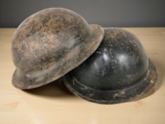 Two 20th century military tin helmets.