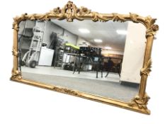 An ornate gilt reproduction overmantel mirror 157 cm x 88 cm
