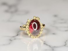 A yellow gold ring set with a cabochon garnet, size O CONDITION REPORT: 3.7g.