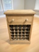 An early 20th century pine single drawer side table with bottle rack beneath,