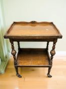 An early 20th century oak two tier trolley with baise lined interior,