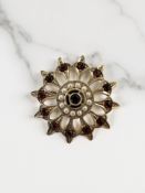 A 9ct yellow gold star burst brooch set with garnets and seed pearls,