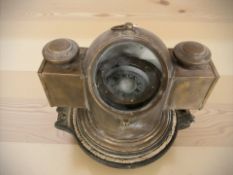 A ship's binnacle compass and a porthole frame.