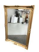 A modern gilt and bevelled overmantle mirror,