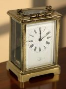 A French brass carriage timepiece, height 14.5 cm including handle.
