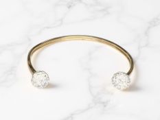 A 9ct gold bangle with faux-diamond terminals, width 6.5cm. CONDITION REPORT: 4.