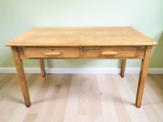 A 1920's oak two drawer writing table, 137 cm x 77 cm x 79 cm.