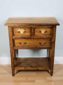 A reproduction three drawer side table,