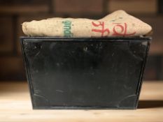 A lacquered metal box and a hessian sack.